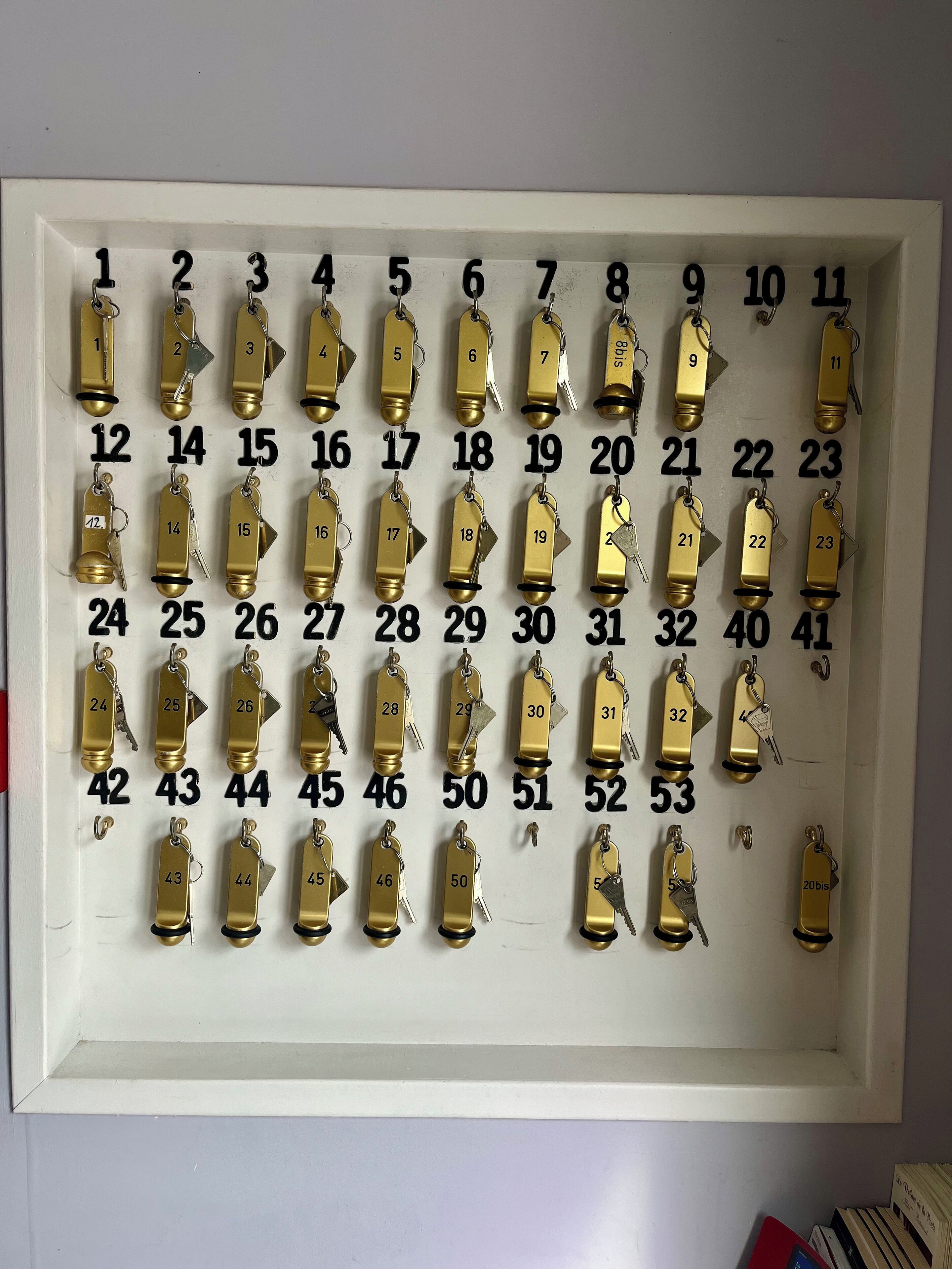A wall-mounted key rack with numbered keys from 1 to 53.