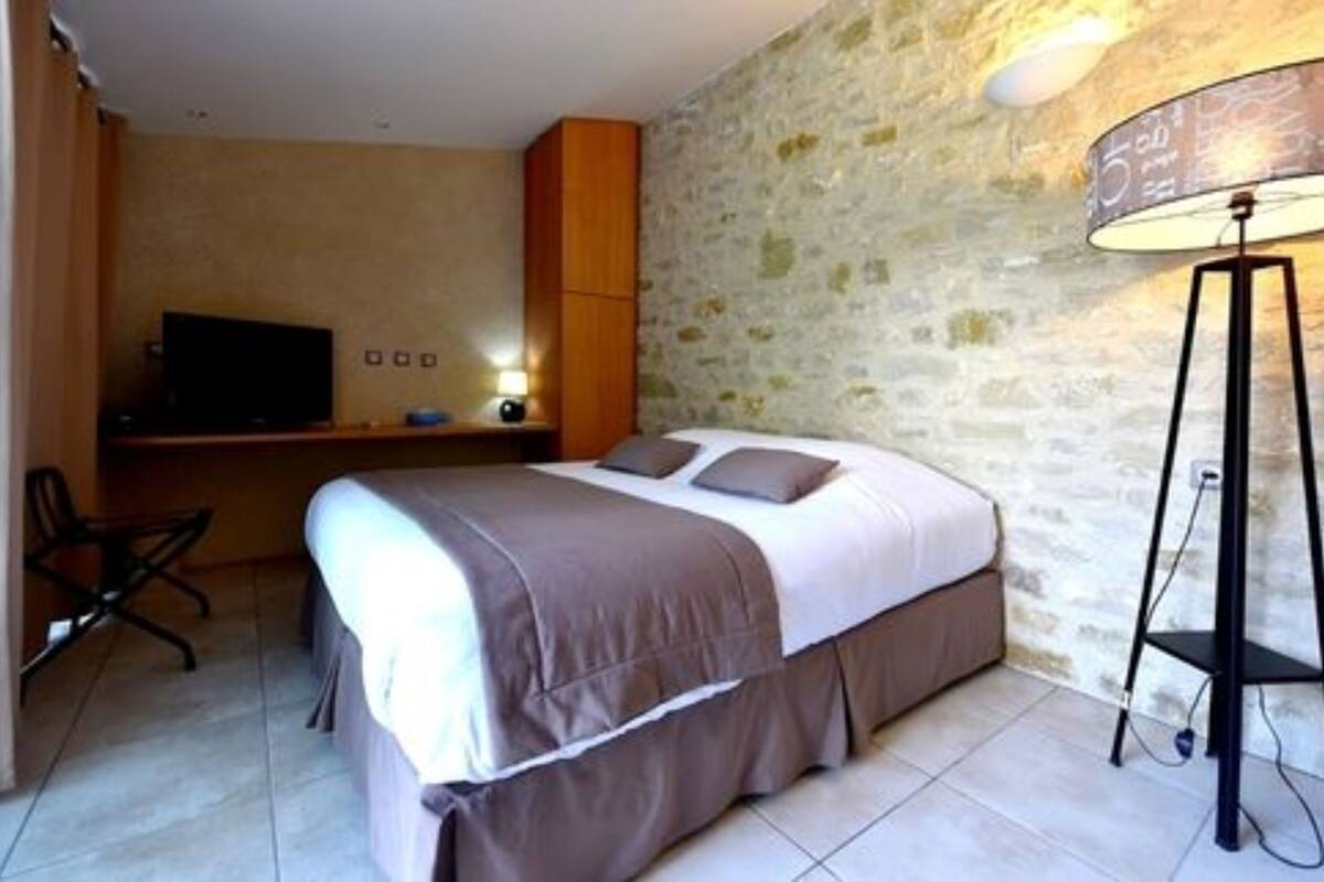 Une chambre à coucher avec un lit, un bureau, une chaise et une lampe.