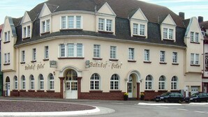 A large, historic building with a curved facade, multiple windows, and a central entrance.