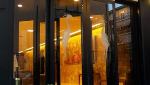 A modern interior with a large window, a visible staircase, and a seating area. - Hotel Airone (Grosseto)