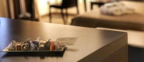 A hotel reception desk with a tray of chocolates and a hotel brochure.