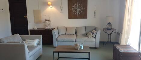 A living room with a sofa, a coffee table, a cabinet, and a suitcase.