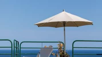 Una piscina al aire libre de temporada, sombrillas