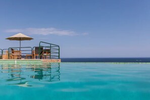 A clear blue pool with a lounge area and an umbrella. - résidence Costa D'oru (Saint-Florent)