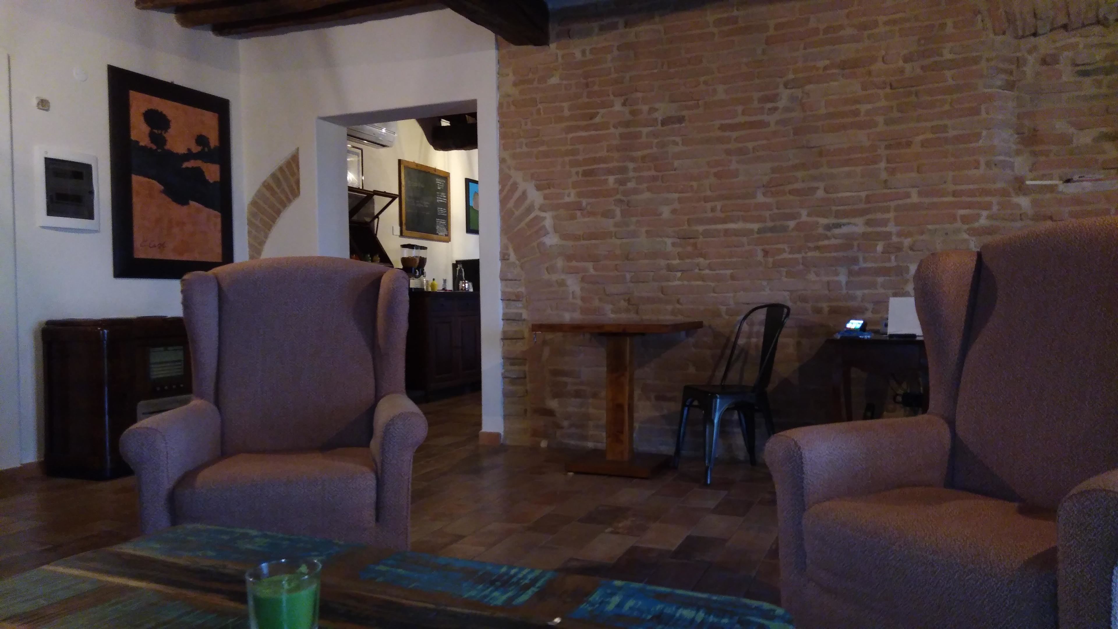 Ein gemütliches Wohnzimmer mit zwei Sesseln, einem Couchtisch und einer Ziegelwand.