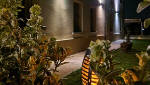 Een modern huis met buitenverlichting en een verzorgd gazon.