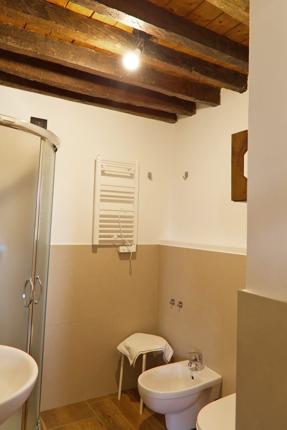 A bathroom with a shower, bidet, and sink.