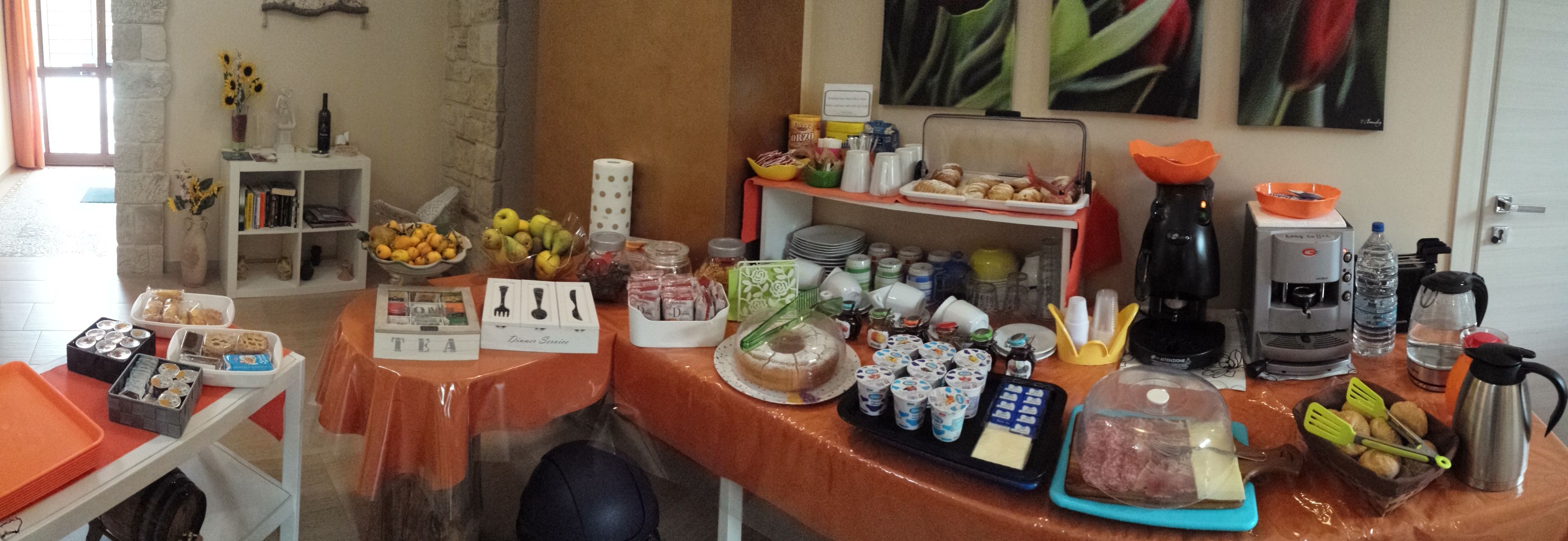 A breakfast buffet with various food items, a coffee machine, and a tea station.