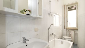 Un baño con lavamanos, bañera e inodoro.