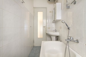 A bathroom with a bathtub, a sink, and a shower. - Impero House Rent - Cavour (Stresa)