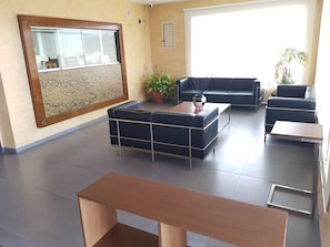 A modern living room with a sofa set, a coffee table, and a wooden bench. - Hostal Millan (Sot de Ferrer)
