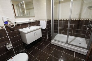 Un baño moderno con ducha, inodoro y lavamanos.