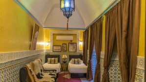 A narrow hallway with two beds, a patterned wall, a hanging lantern, and a red carpet. - Riad Sidi Omar (Marrakech)