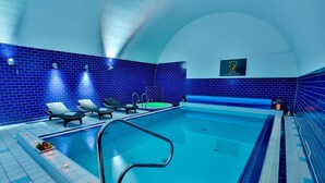 A swimming pool with blue-tiled walls, lounge chairs, and a sign indicating a hotel. - LH Hotel Dvorak Tabor (Tabor)