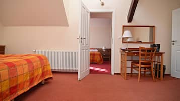 A bedroom with a bed, a desk, a chair, a radiator, a mirror, and a door leading to another room.