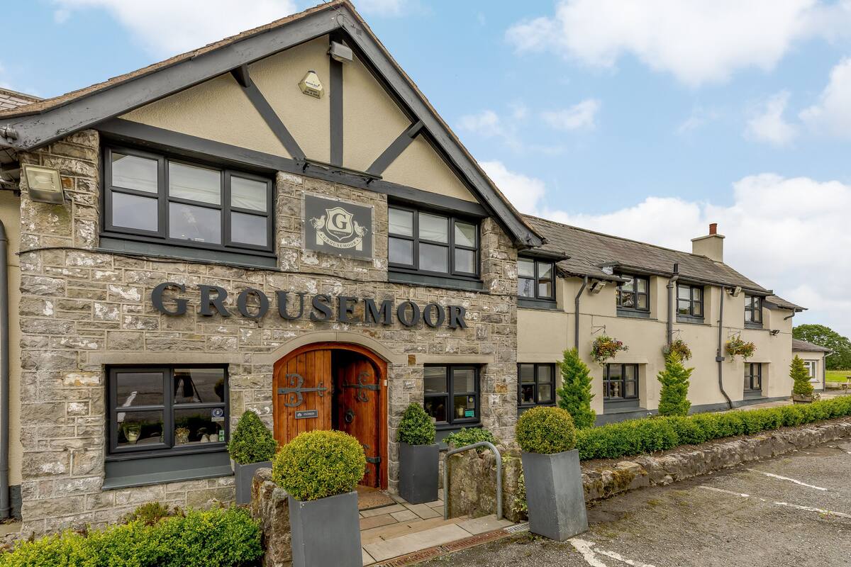 Un edificio de piedra con un letrero que dice "GROUSEMOOR".