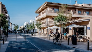 Hotel amb terrassa exterior, carril bici i cel blau clar.