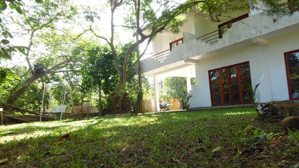 Una casa moderna de dos pisos con un porche cubierto y un columpio.