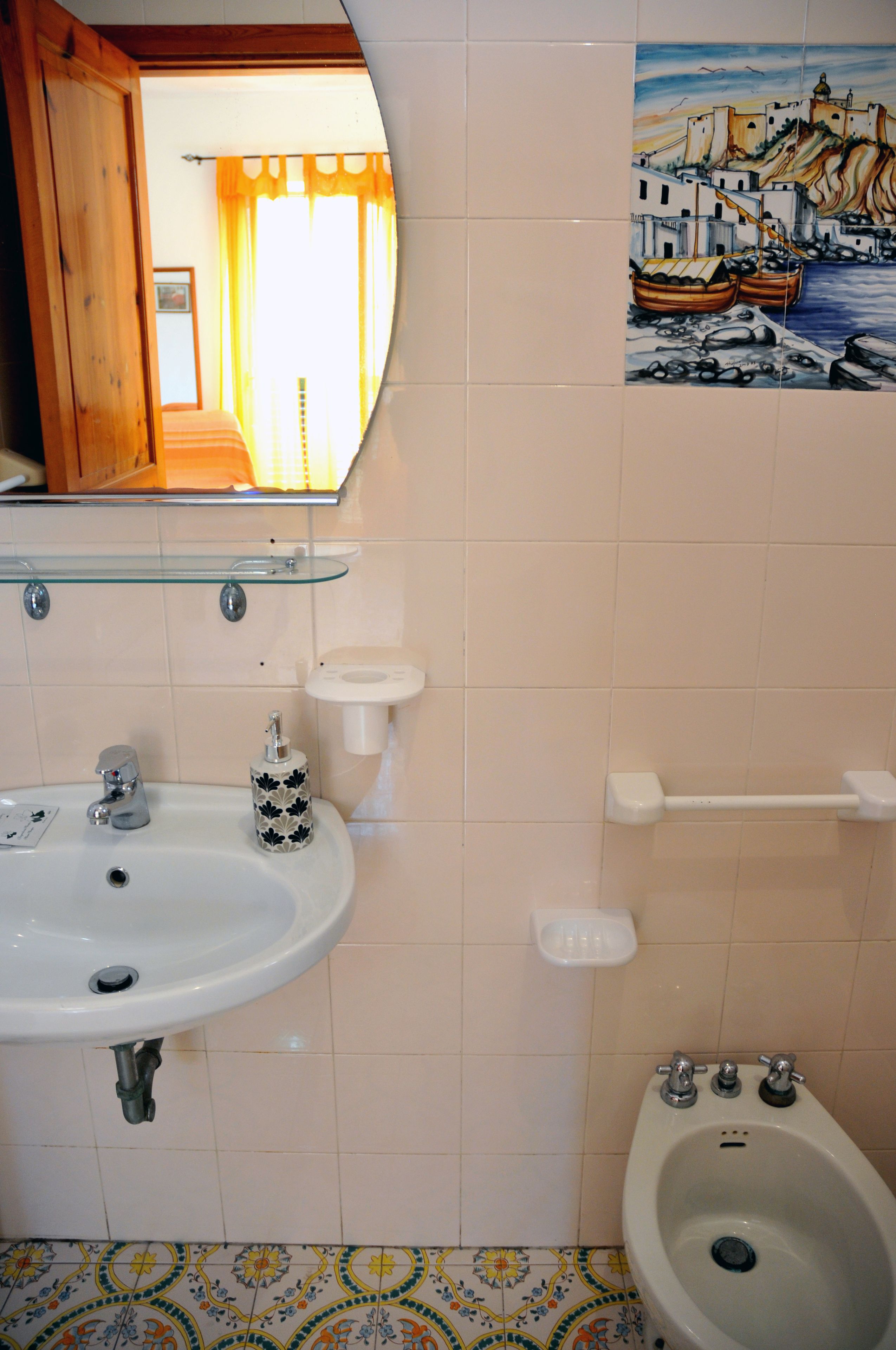 Un baño con lavamanos, bidé y espejo.