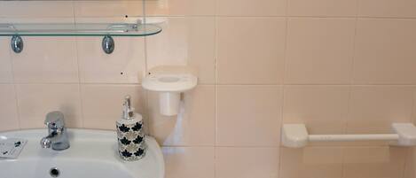 Un baño con lavamanos, bidé y espejo.
