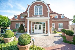 Un edificio de ladrillo con una amplia entrada en arco y el nombre "Landhaus" sobre las puertas.