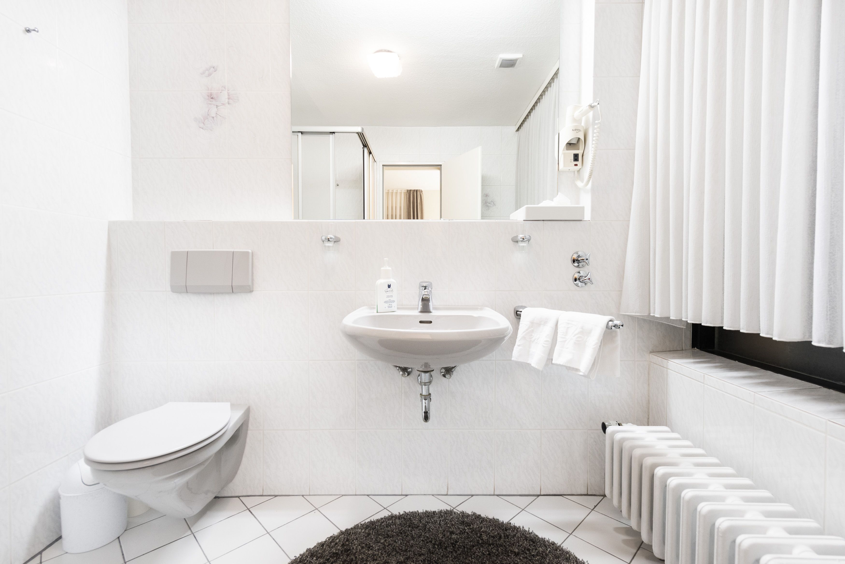 A modern bathroom with a toilet, sink, and shower area.