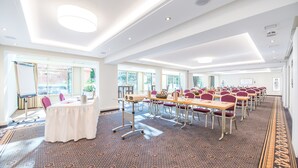 A conference room with a long table, multiple chairs, and a whiteboard. - Hotel Hennies (Isernhagen)
