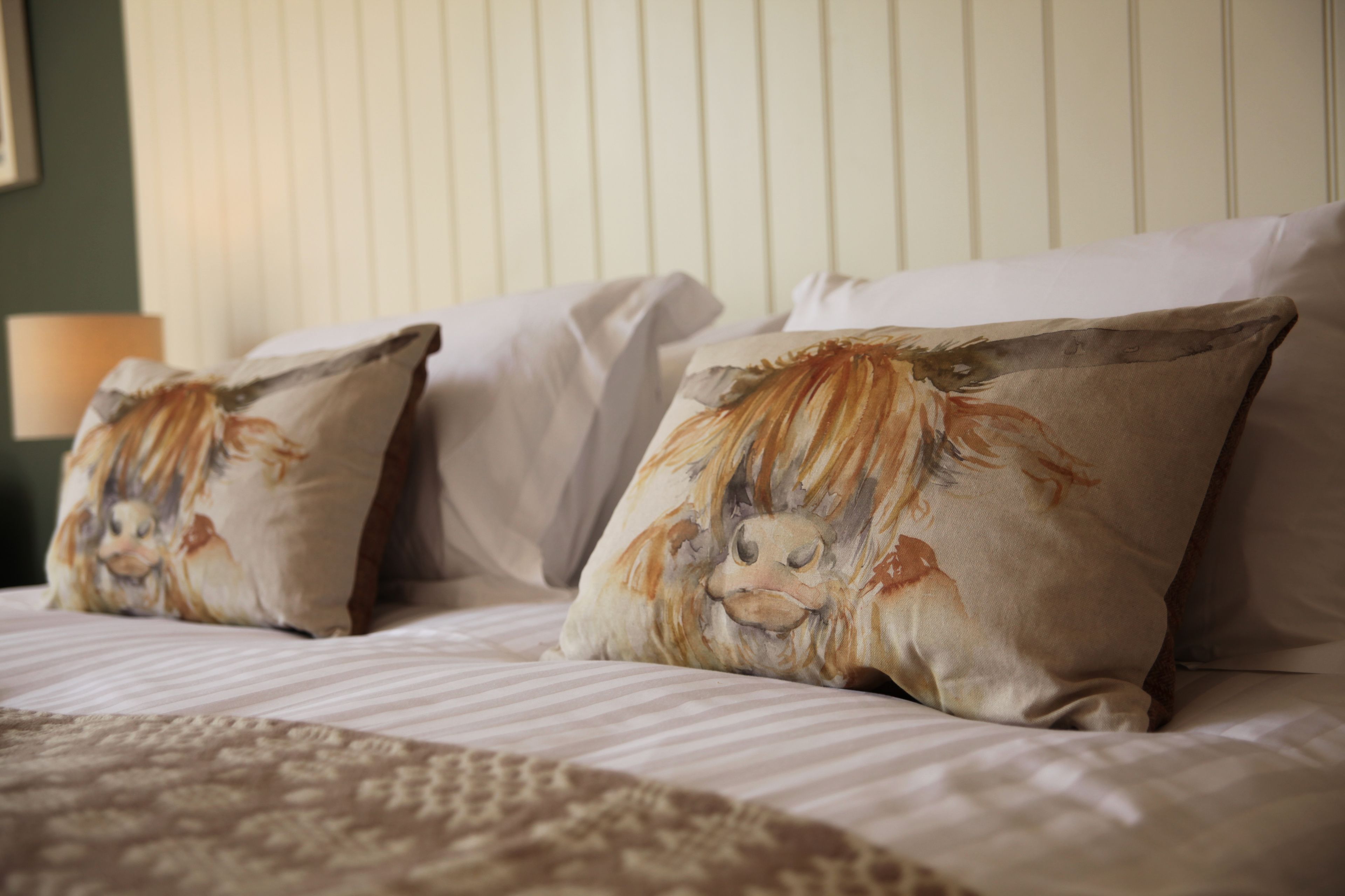A bed with two pillows featuring a lion design.