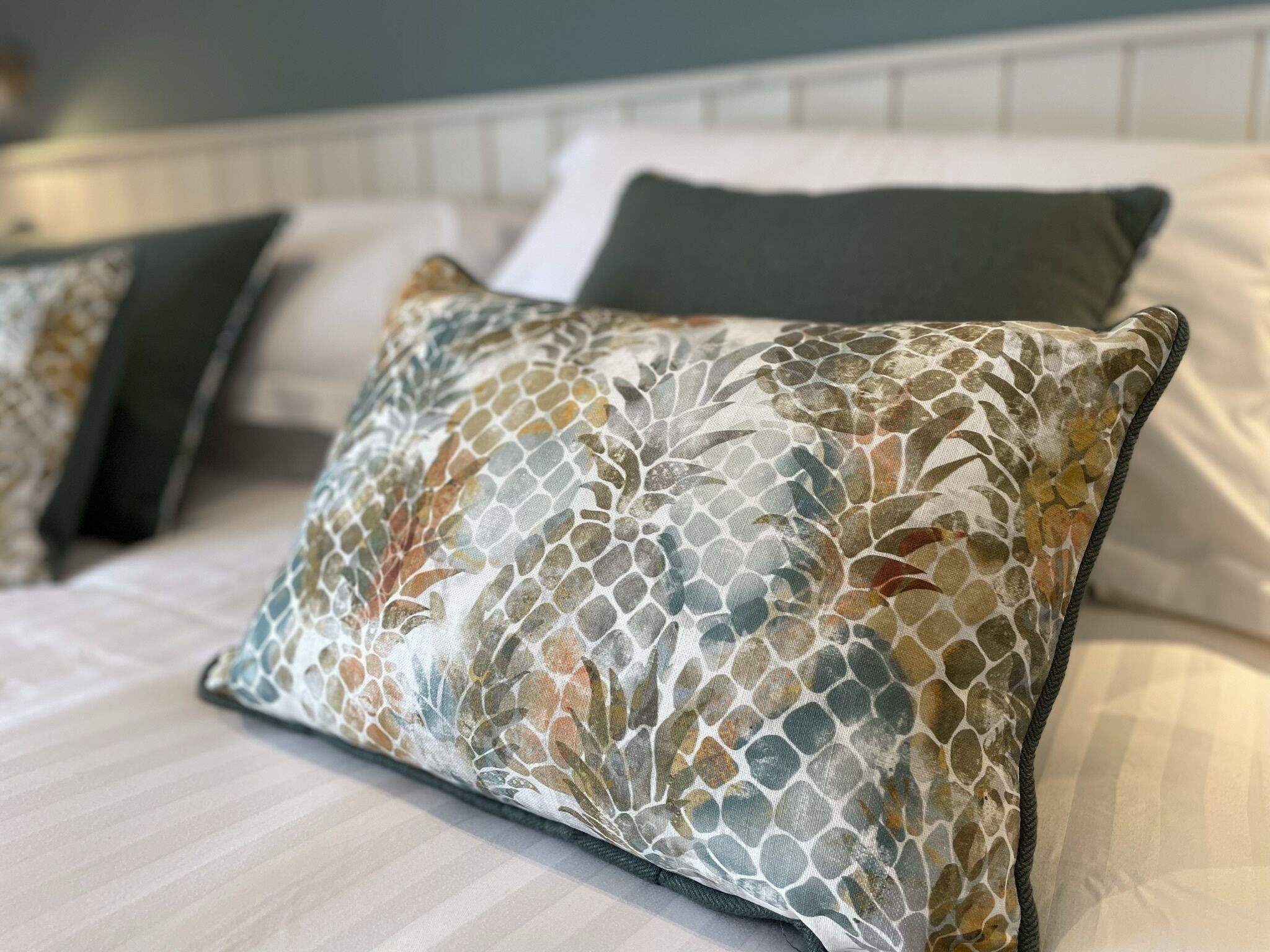 A bed with a patterned pillow and a headboard.