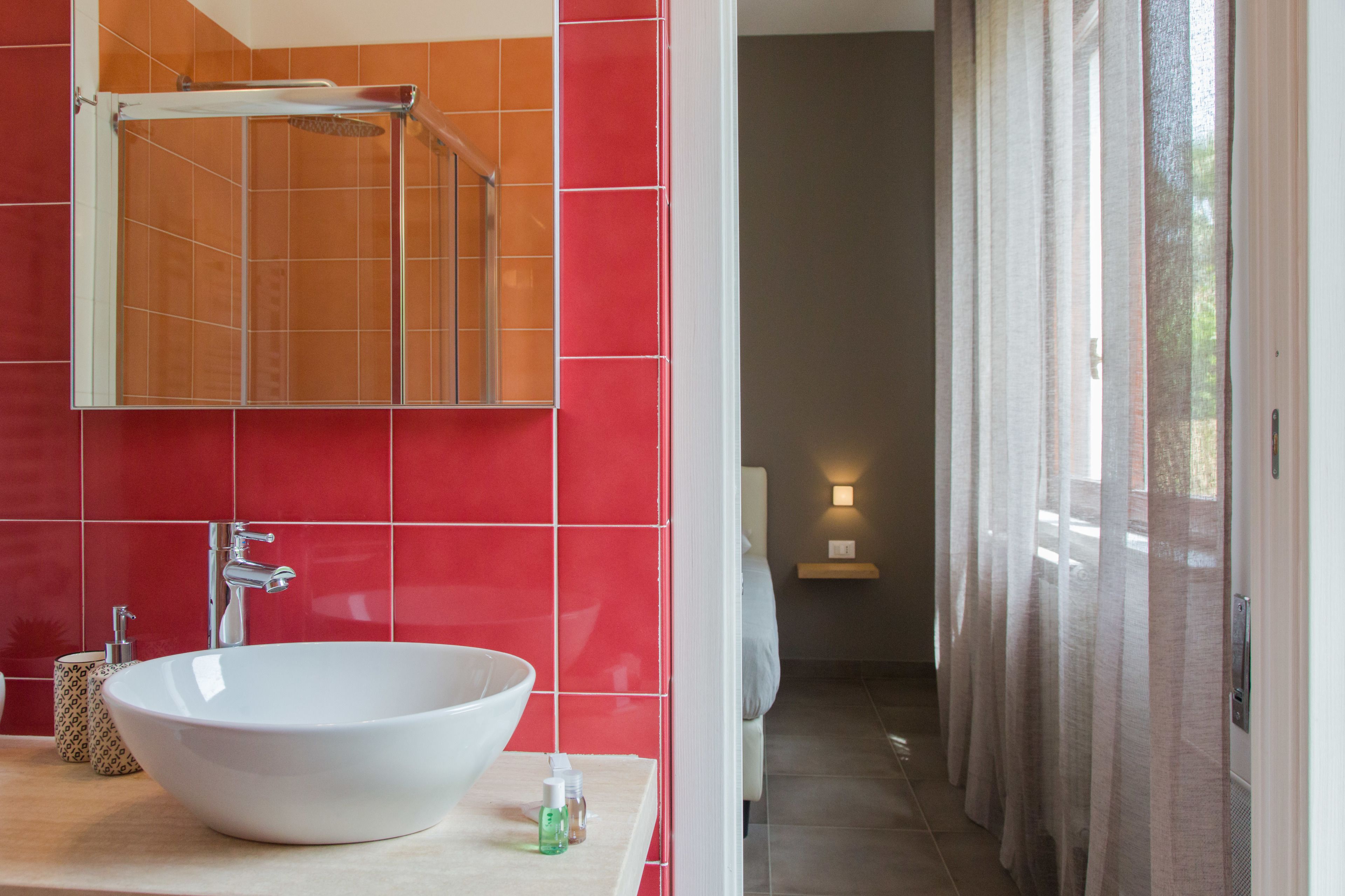 A bathroom with a large white sink, a mirror, and a shower.