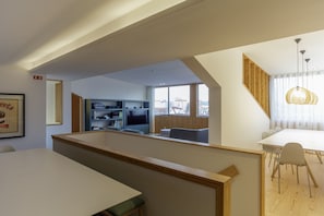 Un interior moderno con comedor, cocina y vistas a la ciudad.
