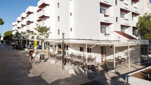 Um edifício moderno e branco com várias varandas e áreas de estar ao ar livre.