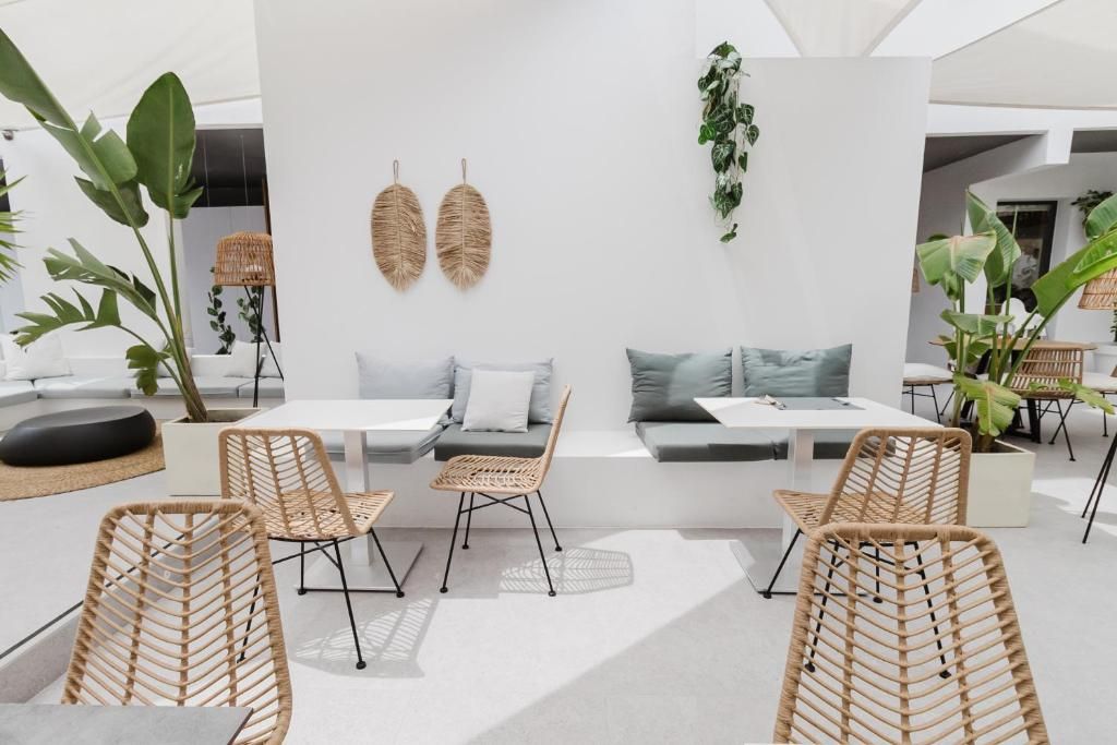 Un espacio habitable moderno y abierto con sofá, mesa de comedor y sillas de ratán.