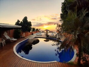 A swimming pool with lounge chairs and a sunset view. - Memorial Ilhabela Residencial (Ilhabela)
