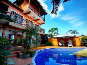A two-story building with a swimming pool, outdoor seating, and a staircase leading to the entrance. - Memorial Ilhabela Residencial (Ilhabela)