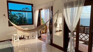 A spacious room with a hammock, large windows, and a view of the ocean. - Memorial Ilhabela Residencial (Ilhabela)