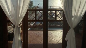 A room with a view of the sea through sheer curtains. - Memorial Ilhabela Residencial (Ilhabela)