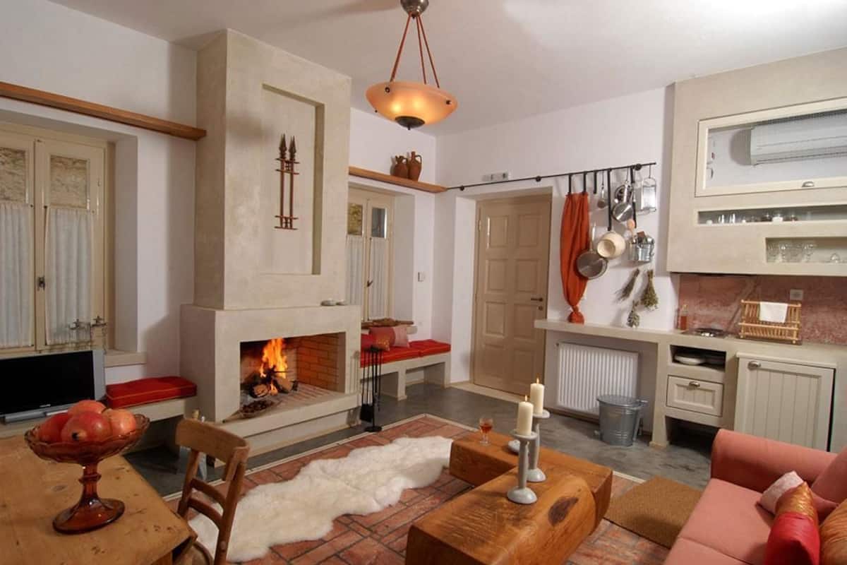 Ein gemütliches Wohnzimmer mit Kamin, Holzmöbeln und einem Fernseher.