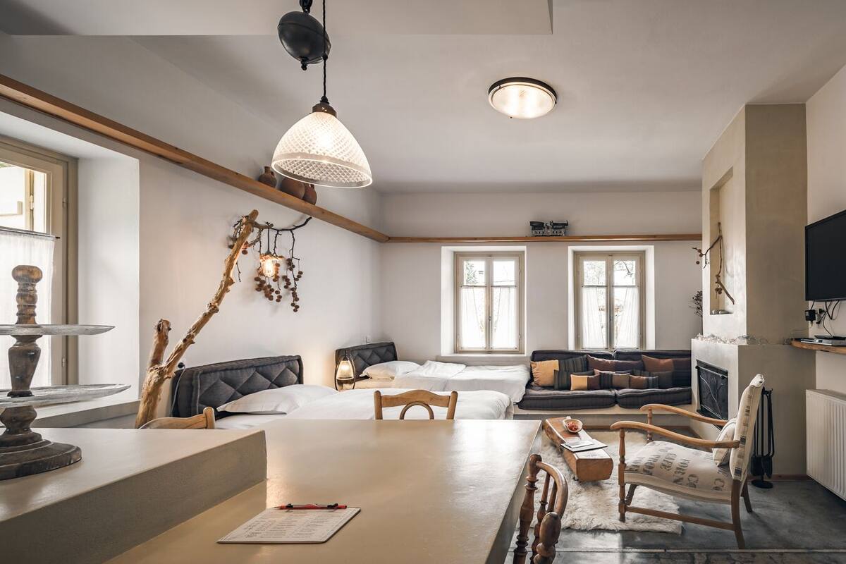 Ein modernes Wohnzimmer mit einer Couch, einem Esstisch und einem Kamin.