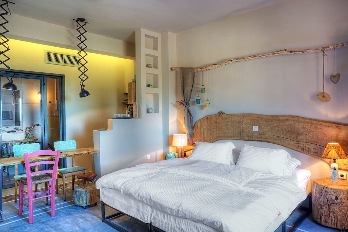 Ein Schlafzimmer mit einem großen Bett, einem Holz-Kopfteil, einem Schreibtisch mit Stuhl und einem Spiegel.