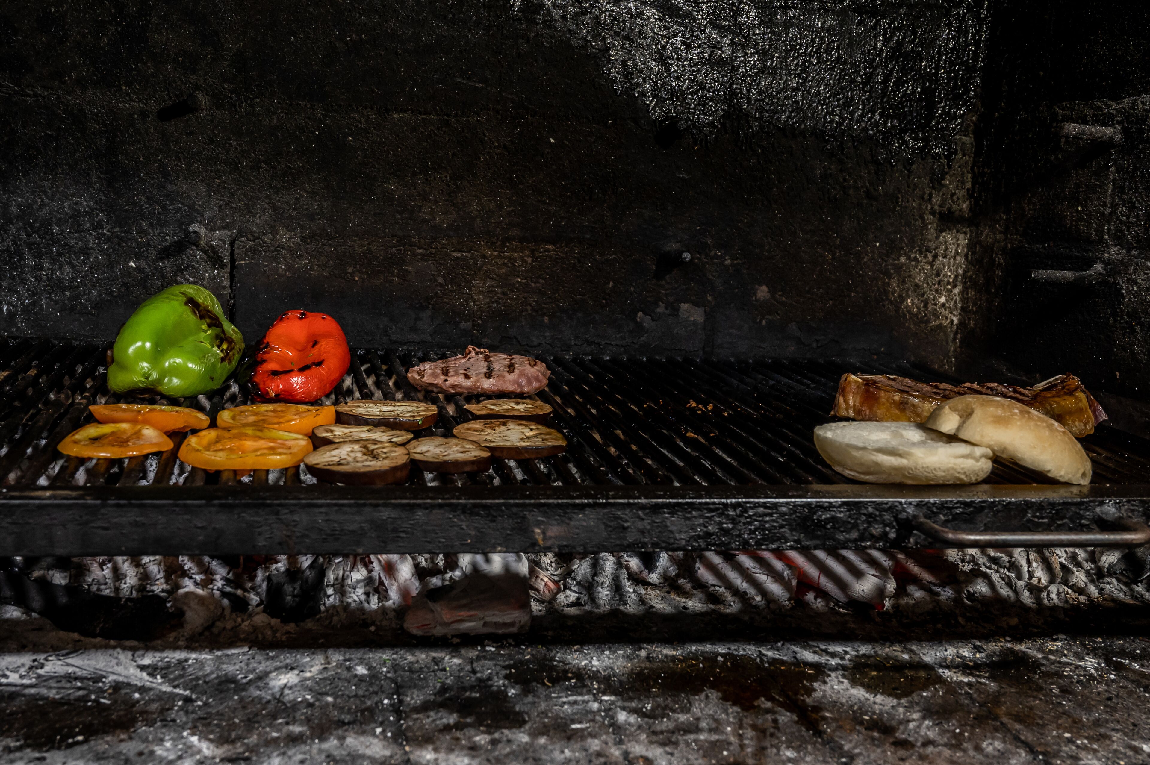 Una parrilla con diversos vegetales y carnes a la cocción.