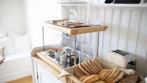 Mesa de desayuno buffet con pan, bollería y salsas.