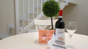 Une table avec une bouteille de vin, un verre, un petit arbre et une boîte cadeau.