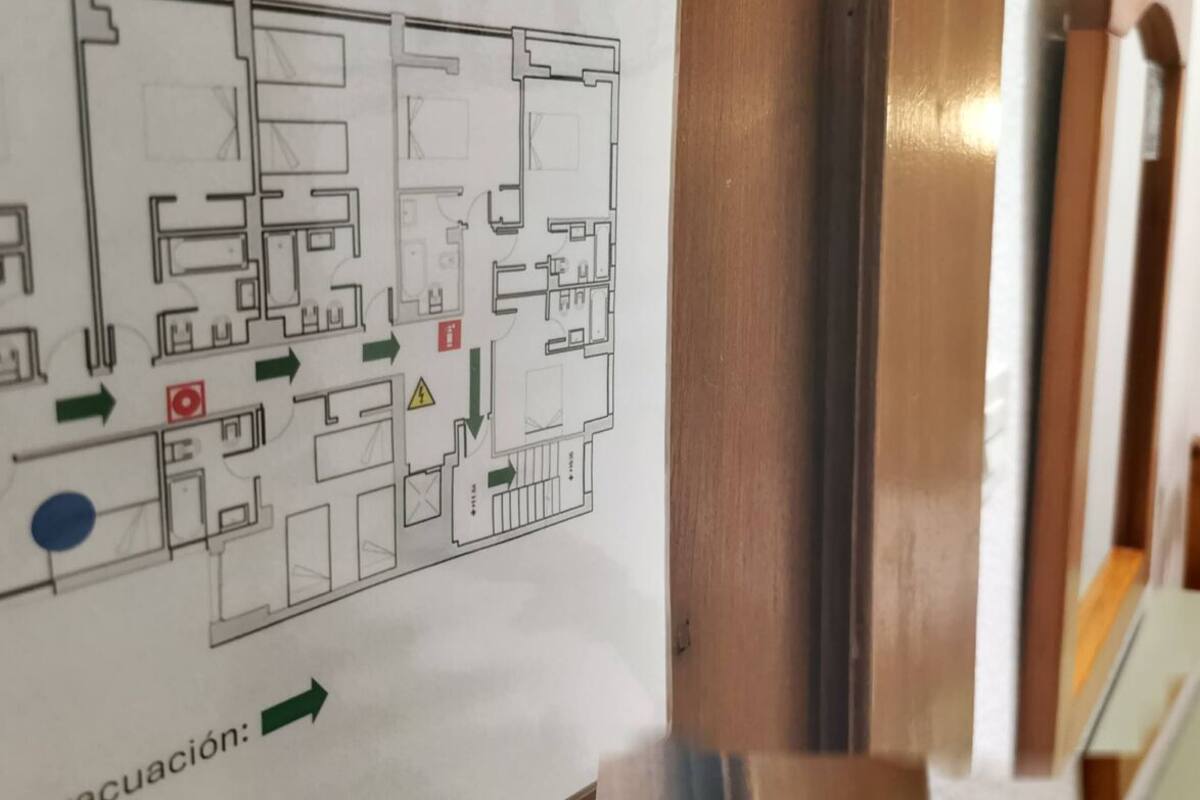 Ein Hotelzimmer mit einem Bett, einem Nachttisch und einer Karte an der Wand.
