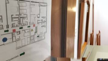 Una habitación de hotel con una cama, una mesita de noche y un mapa en la pared.