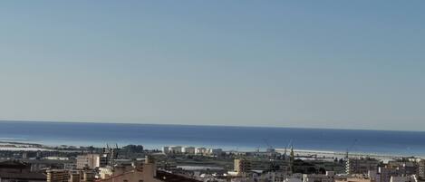 A cityscape with buildings and a clear view of the sea.