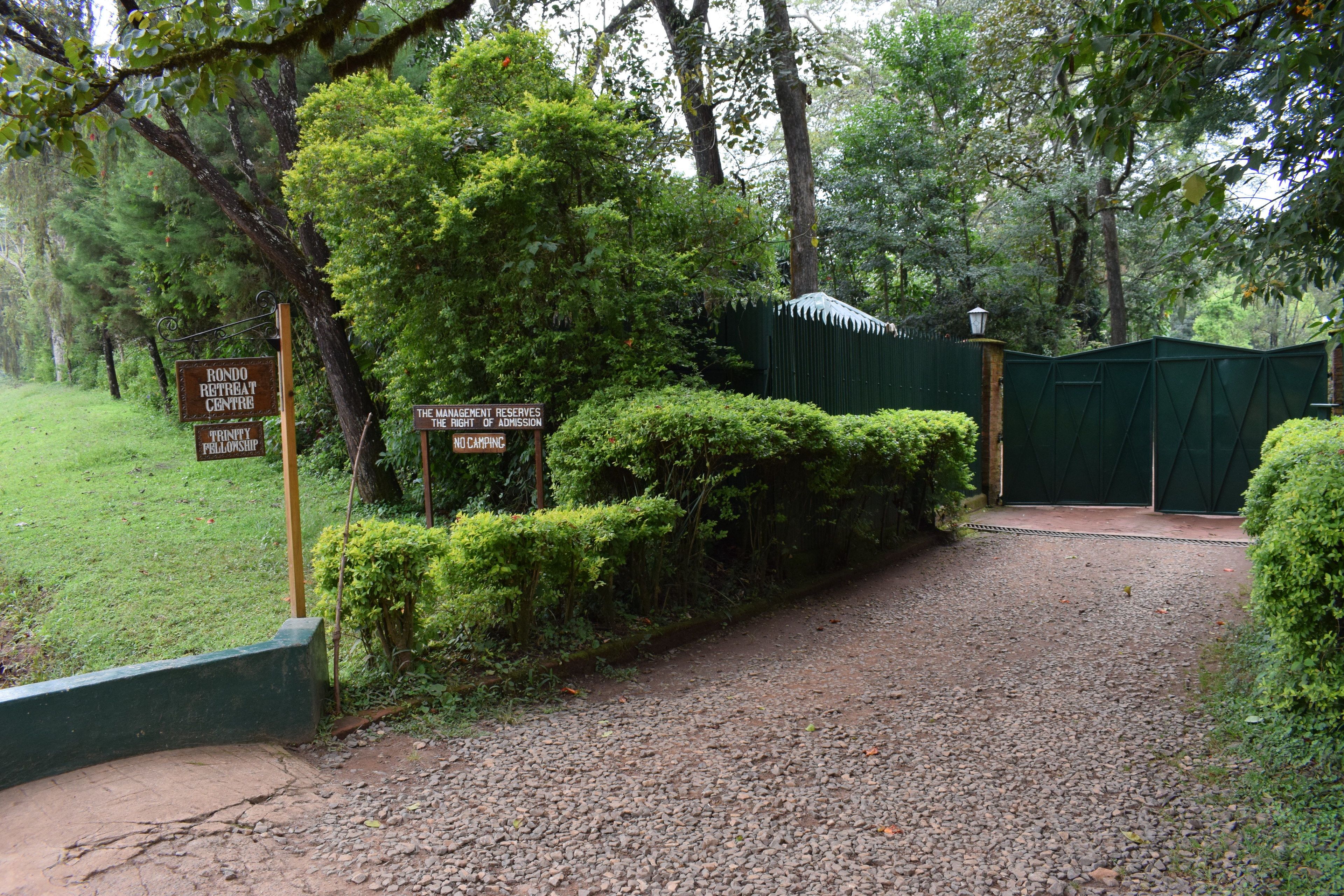 A gravel path leading to a gated entrance with a sign indicating a retreat center.