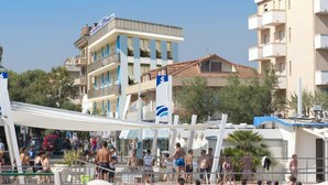 Un hotel con zona de piscina, que incluye una zona de juegos para niños y sombrillas.