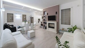 Ein modernes Wohnzimmer mit einer Couch, einem Esstisch und einem Fernseher.