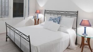 Ein ordentlich eingerichtetes Schlafzimmer mit einem Bett, Nachttischen, Lampen und einer dekorativen Vase.